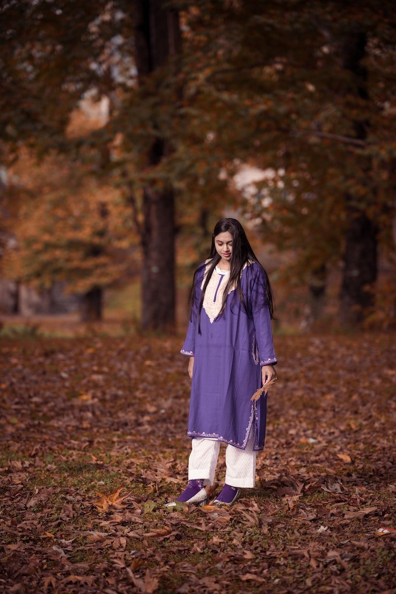 Woman in Blue Pheran Standing on Brown Dried Leaves